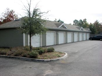 Detached garages with white doors and parking area